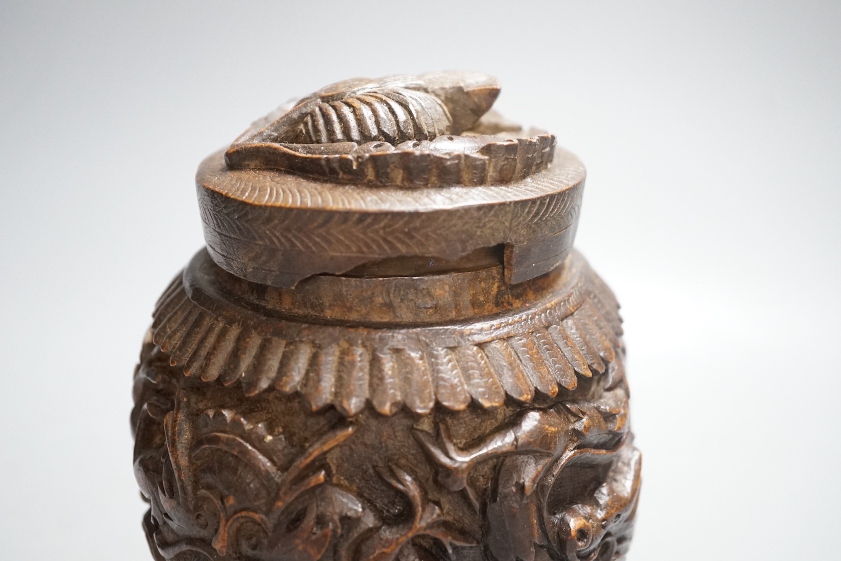 A Burmese carved wooden tobacco jar and cover - 17cm tall